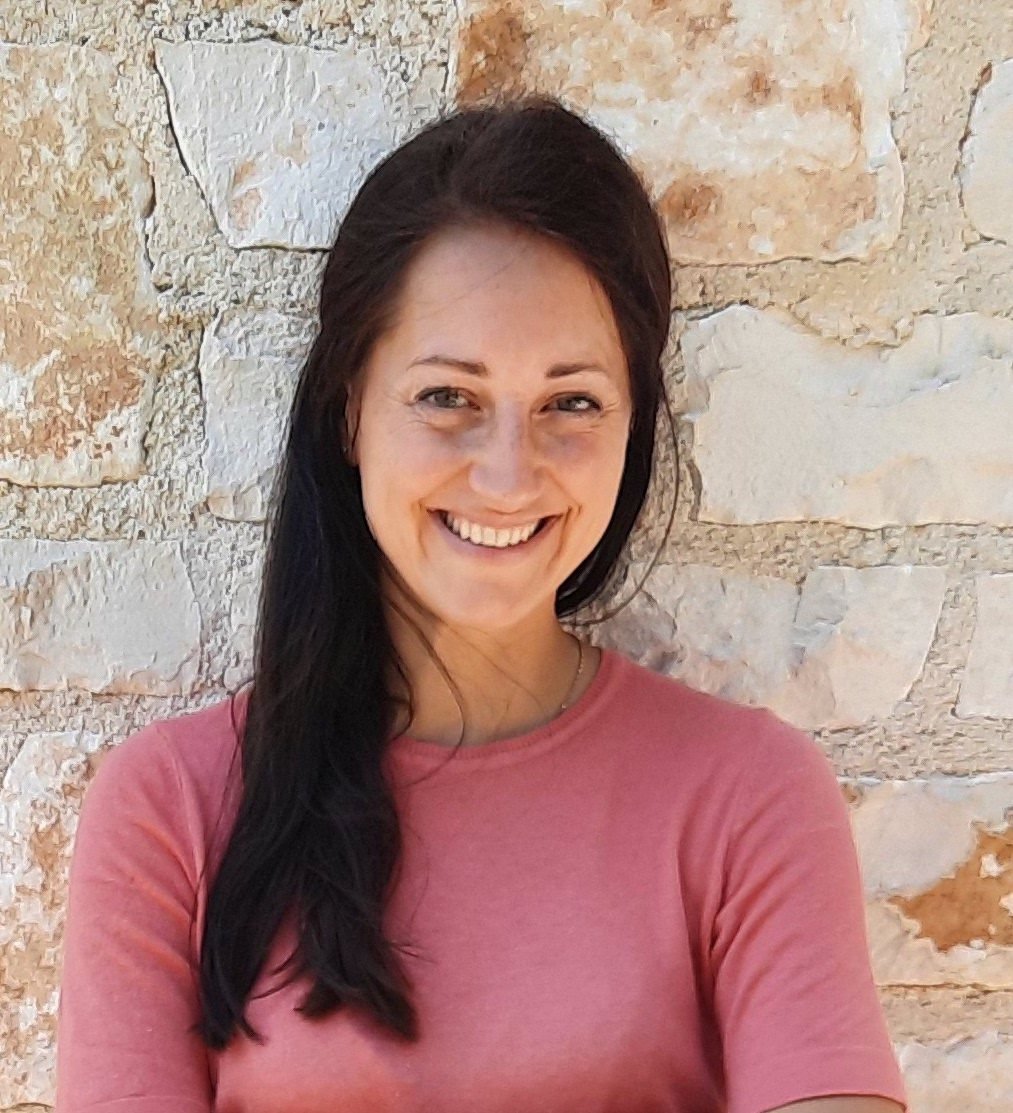 Nicole Künzl trägt ein rosa Sweatshirt und hat langes schwarzes Haar.